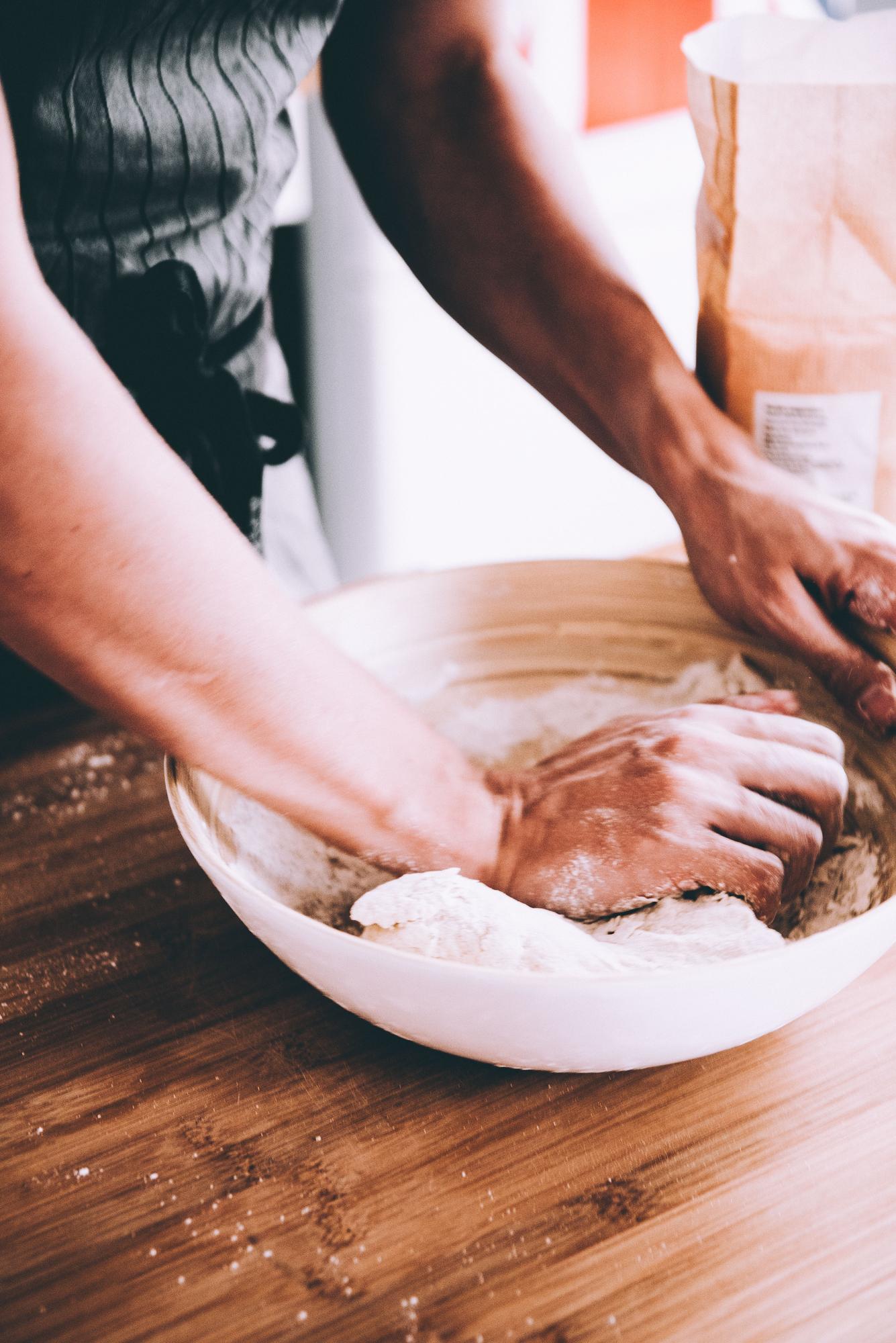 Manos formando masa en cocina artesanal